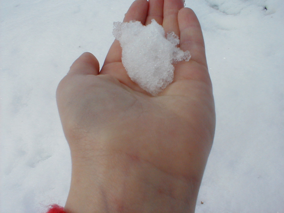 En hånd som holder snø.