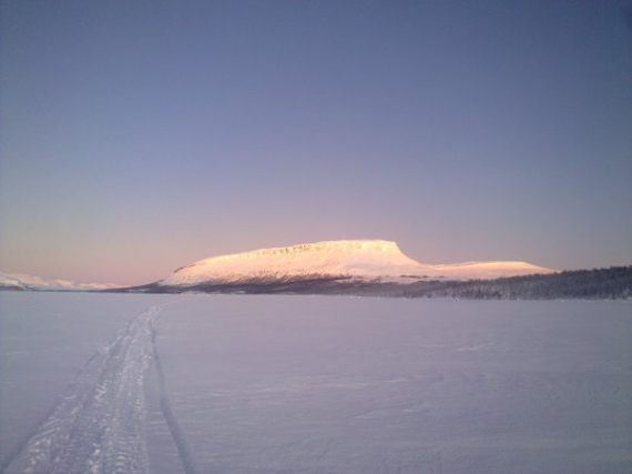 Bilde av en skuterspor på vidda med et fjell i bakrunn.